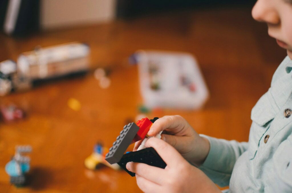 Kind spielt mit Legosteinen